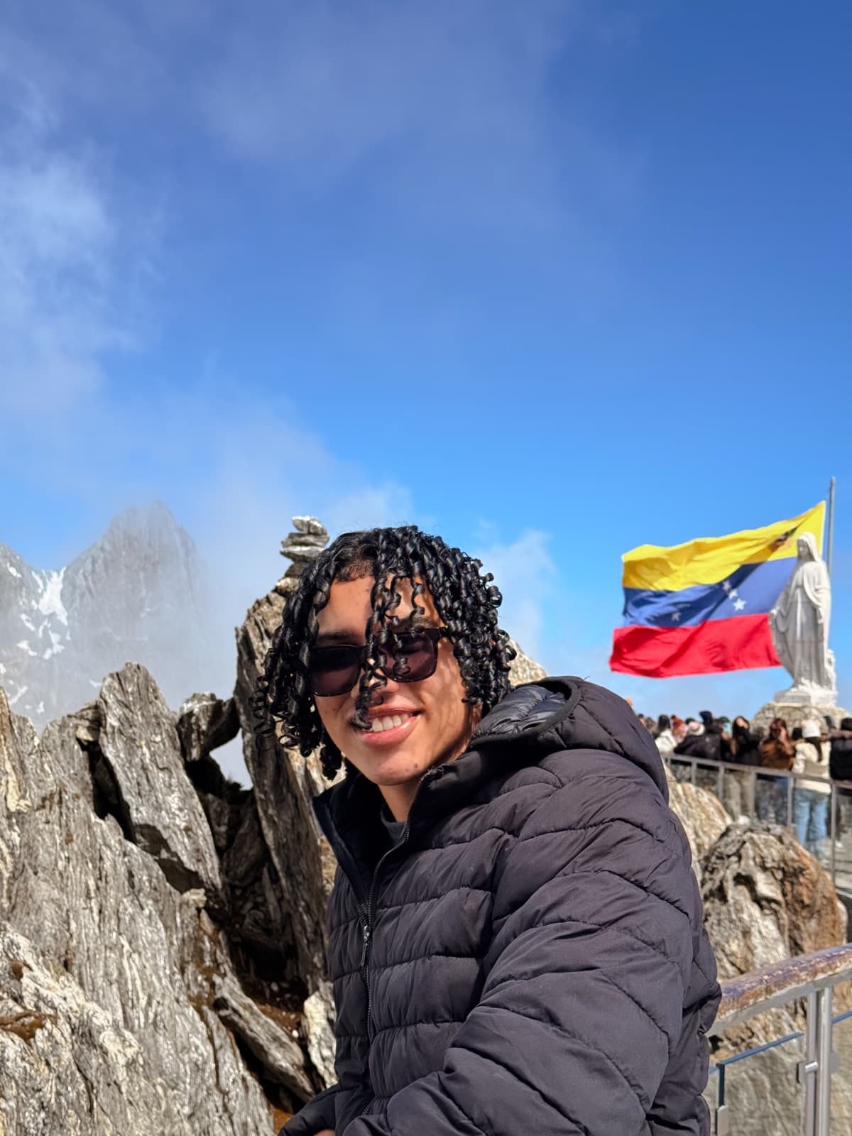 Dylan Allynder en la montaña, con una bandera de Venezuela